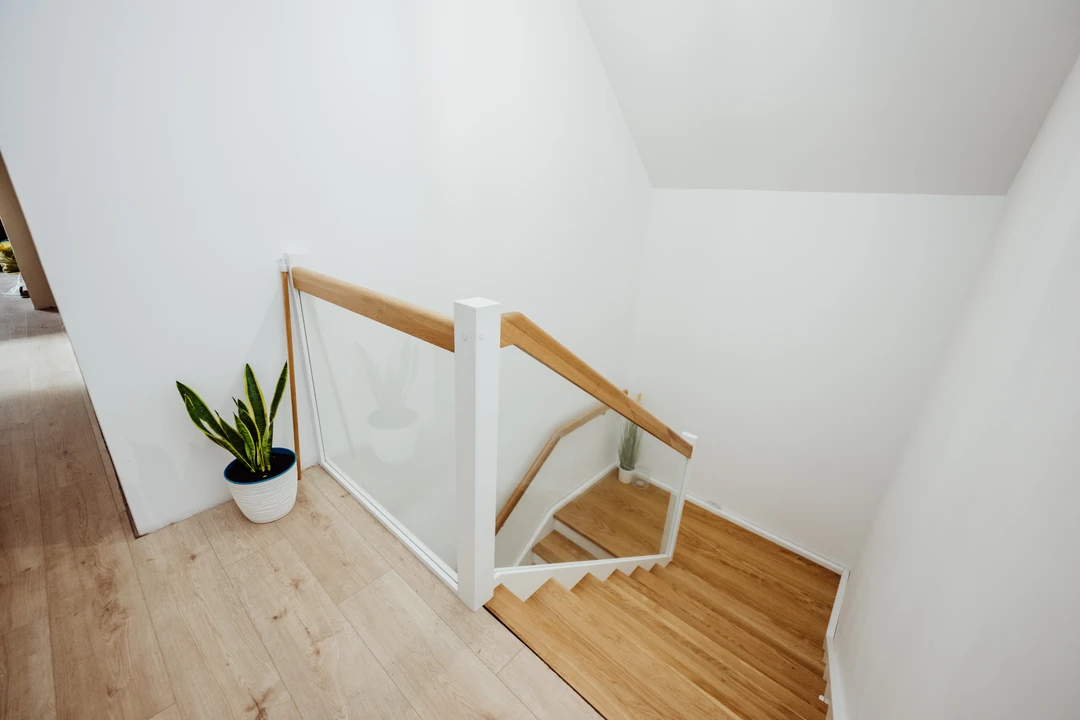 Schody policzkowe z balustradą szklaną i lakierowanymi stopniami 4