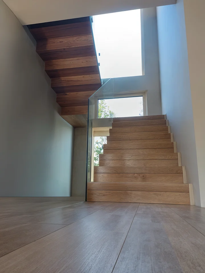 Nowoczesne schody dywanowe z balustradą szklaną
